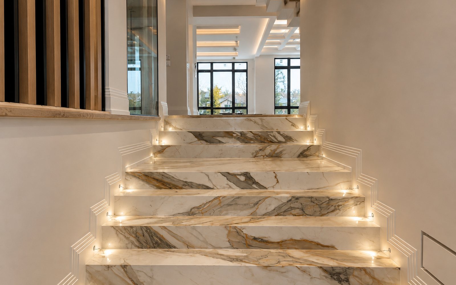 Marble staircase with LED under-step lighting in a home finished by Galactic Renovation in Ontario